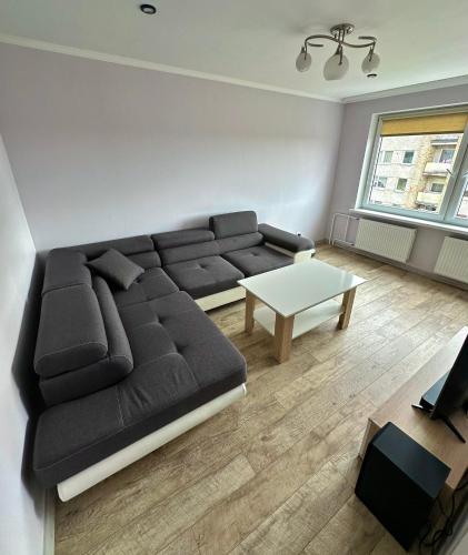 a living room with a black couch and a table at Cozy apartment in Kraslava in Krāslava