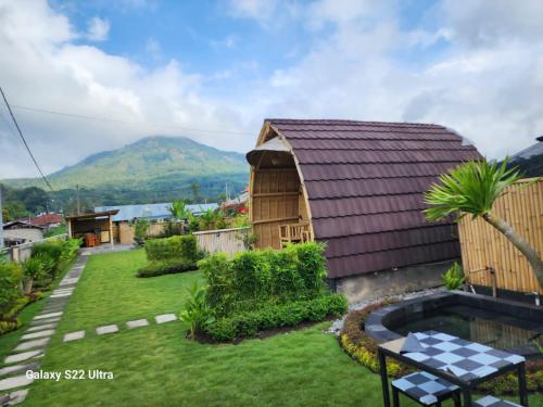 Tegal Bamboo cottages & private hot spring في Baturaja: منزل صغير مع ساحة مع مسبح