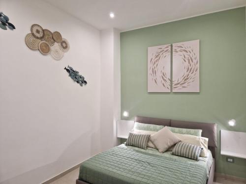 a bedroom with a bed with a green comforter at ondina house in Giardini Naxos