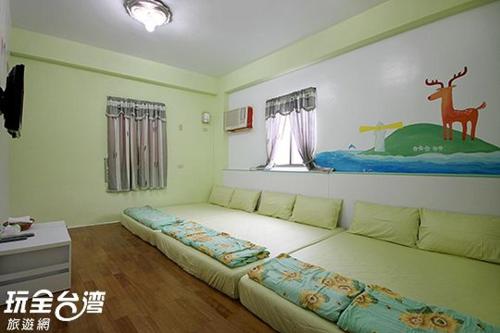 1 dormitorio con 1 cama con un mural de ciervos en la pared en 綠島 梅蓮民宿 機車 潛水 浮潛, en Isla Verde