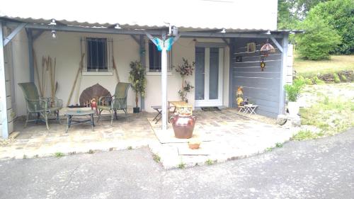 a house with a patio with chairs and a fireplace at La Clef De Voute Amethyste in Saint-Genest