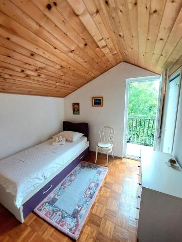 a bedroom with a bed and a large window at Buble Summer House in Rab