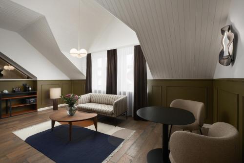 a living room with a couch and a table and chairs at Alda Hotel Reykjavík in Reykjavík