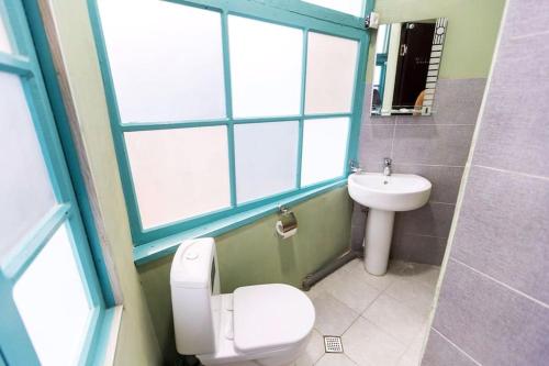 Un baño con inodoro, lavabo y ventana. en OLD Tbilisi ! Старый Тбилиси, en Tiflis