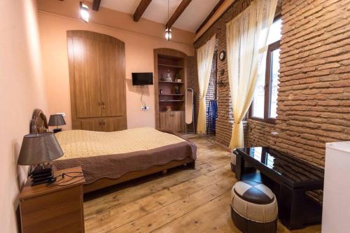 um quarto com uma cama e uma parede de tijolos em OLD Tbilisi ! Старый Тбилиси em Tbilisi