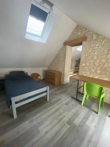 a bedroom with a bed and a desk in a attic at Les Loisons in Beauvoir