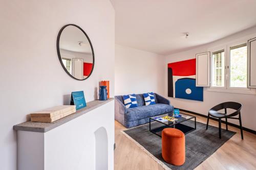 - un salon avec un canapé bleu et un miroir dans l'établissement Sweet Inn - Aragon Park Miro, à Barcelone
