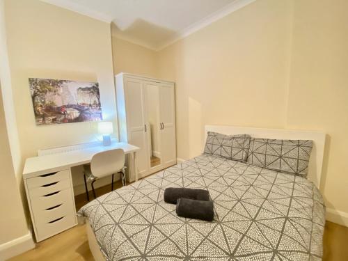 倫敦的住宿－Prime Central London Private Studio Apartment，一间卧室配有一张带书桌的床和一张四柱床。