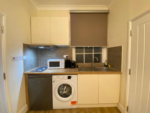 倫敦的住宿－Prime Central London Private Studio Apartment，厨房配有洗衣机和微波炉。