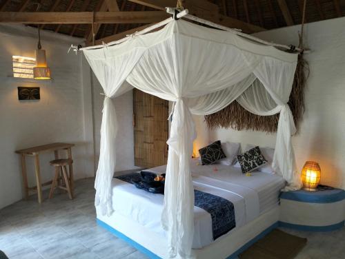 - une chambre avec un lit à baldaquin dans l'établissement SHAYA cottage, à Sekotong