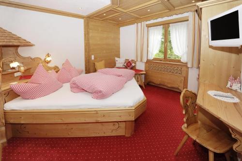 1 dormitorio con 1 cama con almohadas rosas y blancas en Appartements Christophorus, en Sankt Gallenkirch