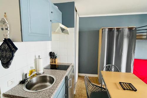 une petite cuisine avec un évier et une table dans l'établissement Lovely studio near the old port and train station, à La Rochelle