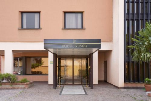 una entrada al hotel con una señal frente a un edificio en Hotel Cyrano, en Saronno