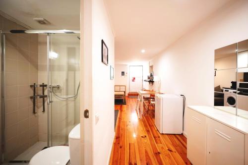 ein Bad mit einer Dusche und eine Küche mit Holzböden in der Unterkunft Apartment in Castelo in Lissabon