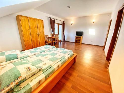 Schlafzimmer mit einem Bett und Holzboden in der Unterkunft Hanu Fain in Reşiţa
