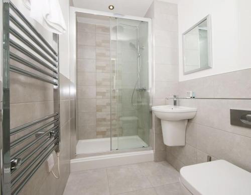 y baño con ducha, aseo y lavamanos. en Modern&Spacious 2 Bedroom Apartment With Parking!, en Hunslet