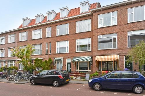 two cars parked in front of a brick building at IVY - Classical & modern apartment in lovely neighbourhood near beach in The Hague