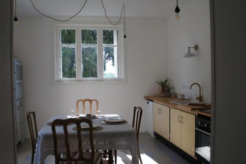 a kitchen with a table and chairs and a window at Les Marronniers @ Cinq La Voûte in Ambleville