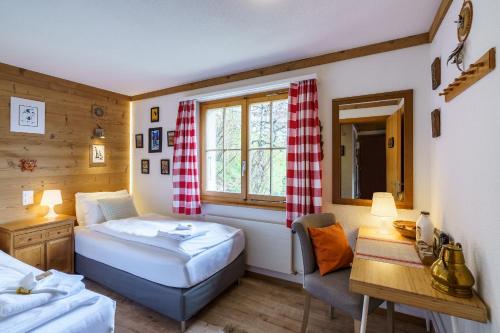 ヴェンゲンにあるChalet Bergkristallのベッドルーム1室(ベッド2台、デスク、窓付)