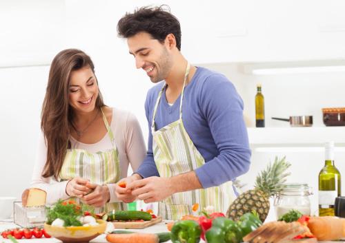 un hombre y una mujer preparando comida en la cocina en Executive Apartment’s Mk, en Milton Keynes