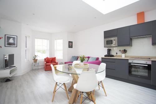 cocina y sala de estar con mesa y sillas en Oceans 12a Shelley Lofts, sleeps 4 en Worthing