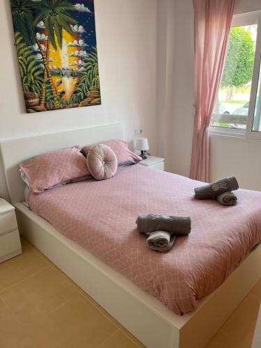 a bedroom with a pink bed with two towels on it at Vista Verde in Murcia