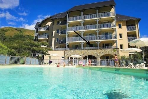 un hôtel avec une piscine devant un immeuble dans l'établissement Appart. 4 couchages 3 étoiles - Accès télécabine, à Saint-Lary-Soulan