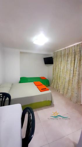 a small room with a bed and a curtain at Habitación Triple Equipada, Posada Villa Mayo a 5 minutos de Playa Parguito in Loma de Guerra