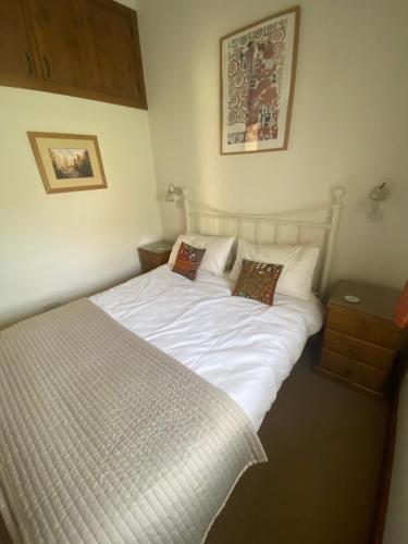 a bed with white sheets and pillows in a bedroom at Kennick Barn, peace and quiet guaranteed, Dartmoor in Christow