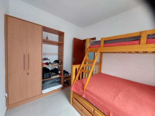 um quarto com um beliche e um armário em Apartamento Ubatuba Maranduba 150m da Praia em Ubatuba
