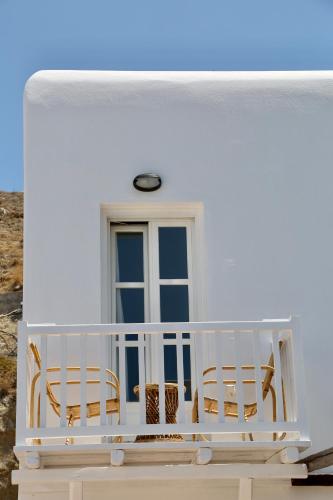 a white house with two chairs and a window at Ubud Mykonos in Agios Ioannis Mykonos