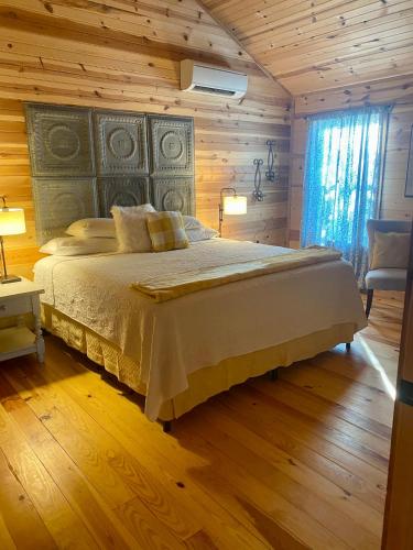 a bedroom with a large bed with a wooden wall at City on a Hill at Spring Creek in Fredericksburg