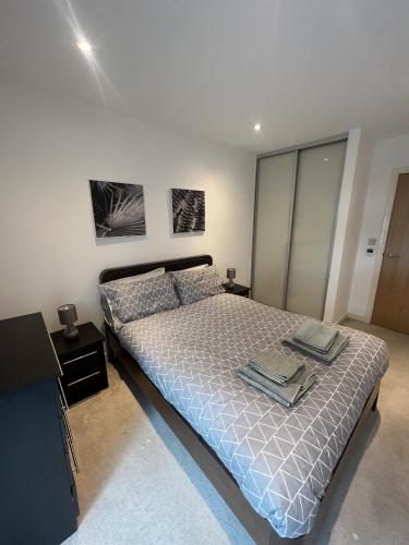 クロイドンにあるLuxurious 1 Bedroom Apartment In Croydonのベッドルーム1室(ベッド1台付)が備わります。壁に2枚の写真が飾られています。