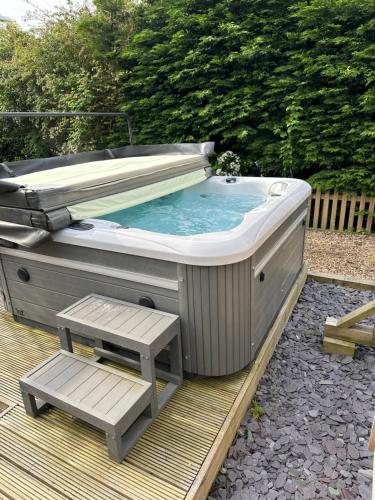 a hot tub with a bench sitting next to it at The White Hart in Widworthy