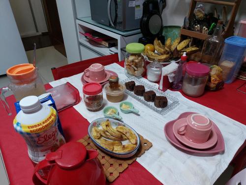 una mesa con un mantel rojo con comida. en Quarto TRIPLO CONFORTAVEL E AMPLO NO BAIRRO DO ESPINHEIRO em RECIFE en Recife