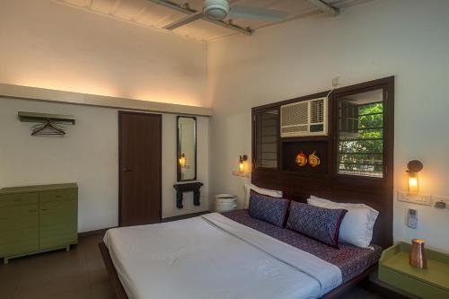 a bedroom with a large bed and a window at SaffronStays Artica - 2 BDR cottage near Fariyas in Lonavala in Lonavala