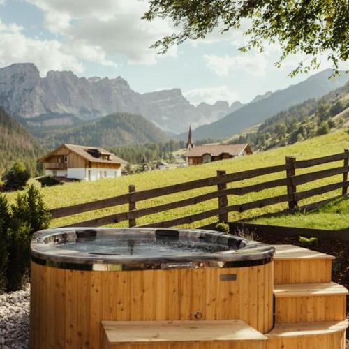 a wooden hot tub sitting next to a fence at Ostí Vedl in San Martino in Badia