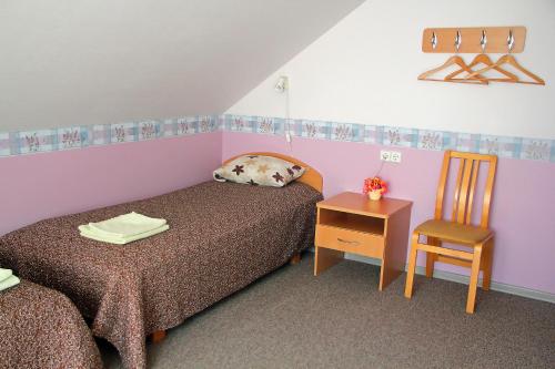 a small room with two beds and a chair at Rivaal Guesthouse-Cafe in Põltsamaa