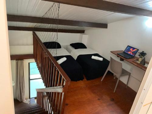 a bedroom with a bed and a desk with a laptop at Flat 402 Laguna Beach - tipo Loft encantador, mobiliado e aconchegante in Porto De Galinhas