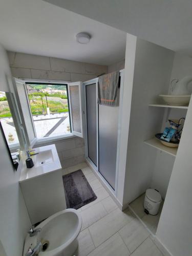 La salle de bains est pourvue d'un lavabo, de toilettes et d'une fenêtre. dans l'établissement Pousada da Vila, à Vila Franca do Campo