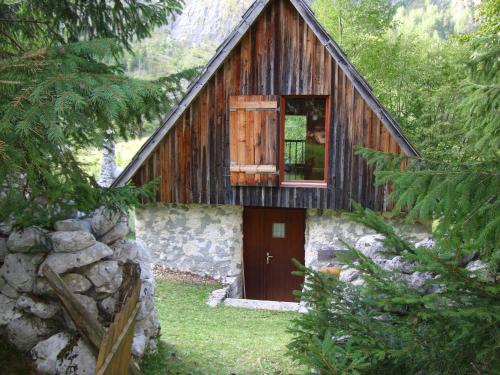 a wooden house with a red door in a forest at House Pod Lipo in Trenta