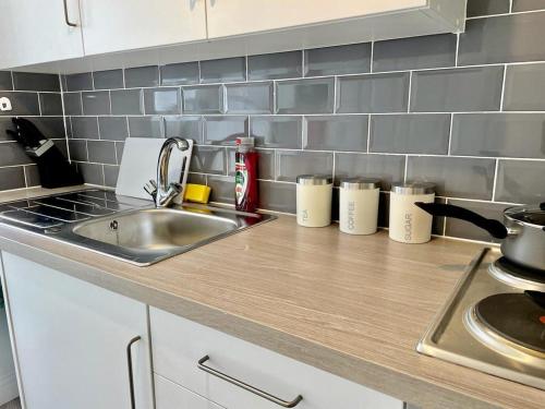a kitchen with a sink and a counter top at Cosy 1-Bedroom Apartment Briton Ferry, Neath Port Talbot in Briton Ferry