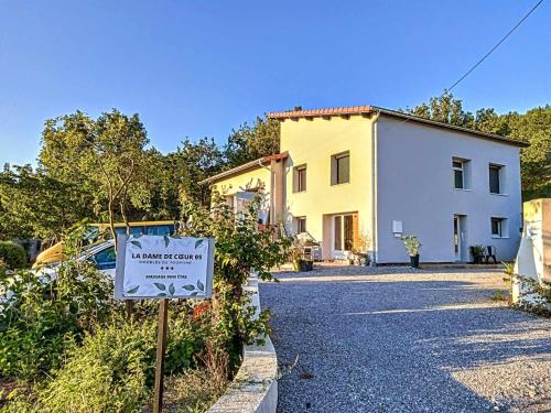 a sign in front of a house with a building at La Dame de cœur 05 in Antonaves