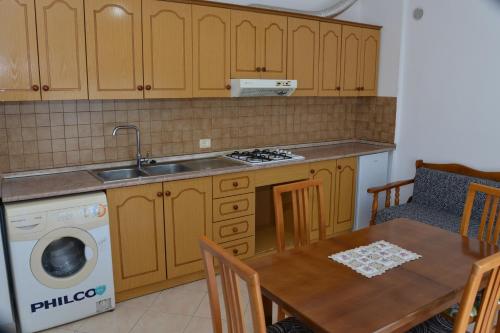 una cucina con tavolo, lavandino e lavastoviglie di Cheap and Cozy Apartments for rent in Durres 100m by the beach a Durrës
