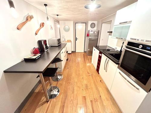 Il comprend une cuisine avec un comptoir noir et du parquet. dans l'établissement Charmante maison de montagne pour 8 personnes, à Livet-et-Gavet