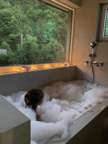 a woman is in a bath tub filled with foam at Villa Rivus in Sarajevo