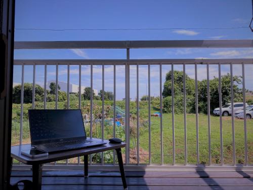 un ordenador portátil sentado en una mesa en un balcón en Shonan no Oka no Villa - Vacation STAY 24013v, en Fujisawa