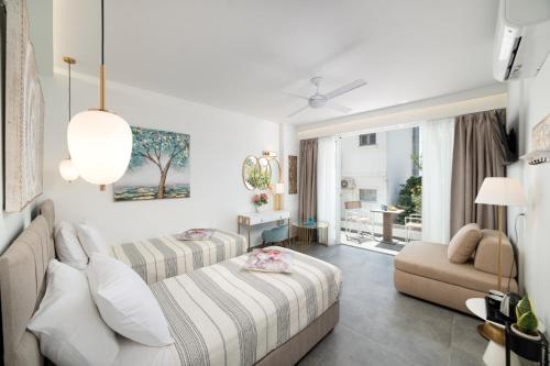 una habitación de hotel con dos camas y un sofá en Serenita premiums apartment 3, en Agios Nikolaos