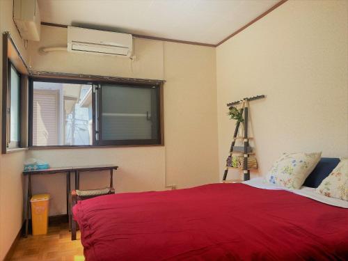 a bedroom with a red bed and a window at Shonan no Oka no Villa - Vacation STAY 24987v in Fujisawa