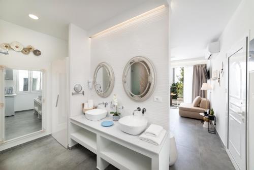 Un baño blanco con dos lavabos y un espejo. en Serenita premiums apartment 3, en Agios Nikolaos